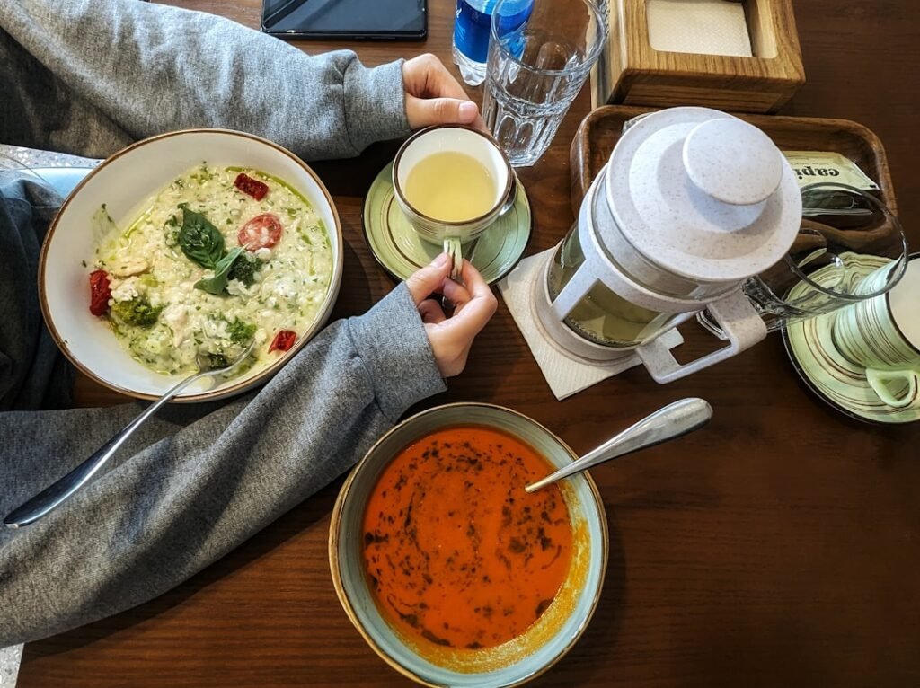 Person eating a hot bowl of soup at a table